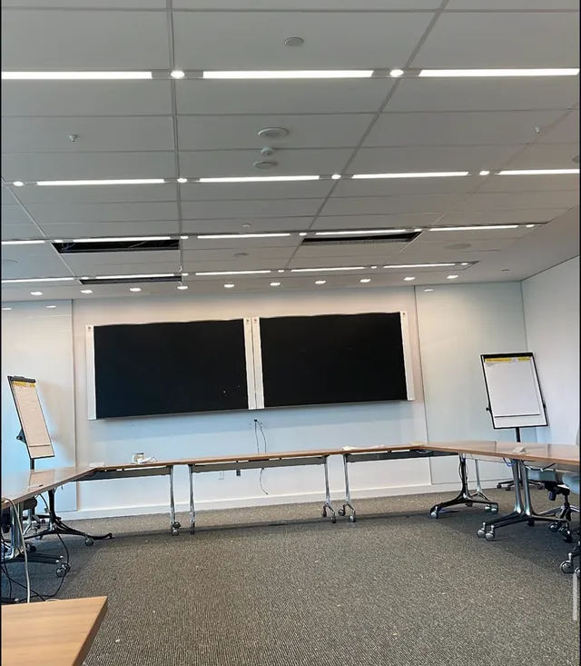 Large conference room with dual 98-inch displays and ceiling speakers