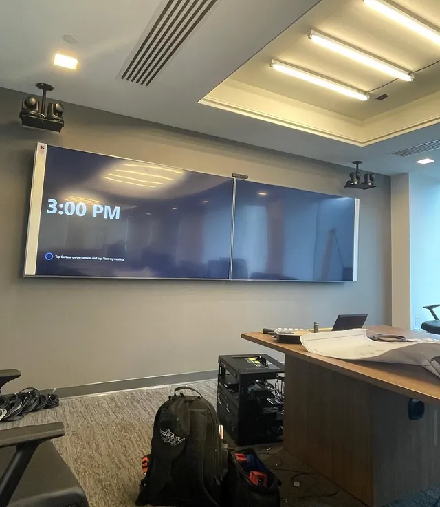Conference room with two 85-inch displays and ceiling-mounted presenter tracking cameras