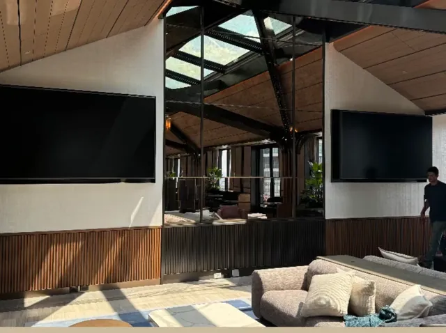 Two 98-inch displays installed in an open lounge by Wired By Pete