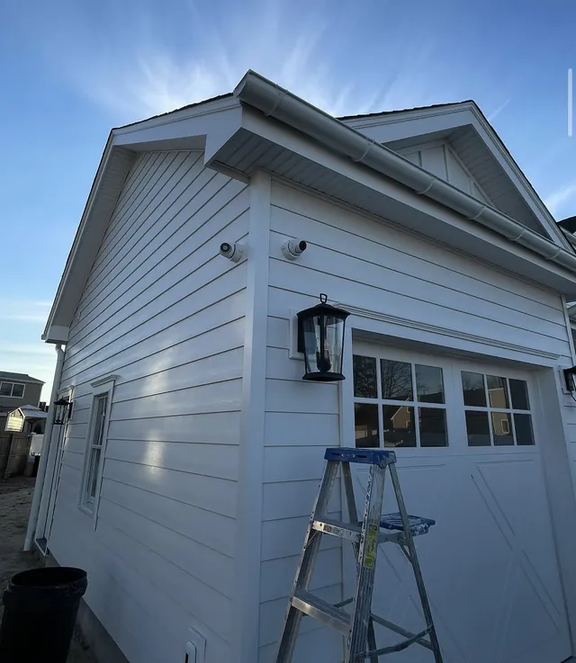 Security cameras mounted on the corner of a white garage