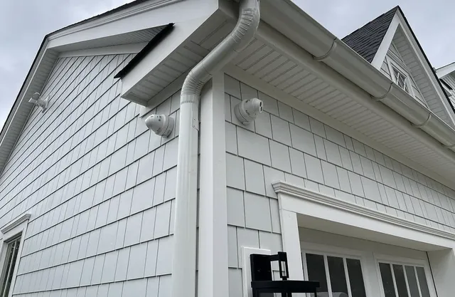 Home security cameras mounted on shingle siding of a new house