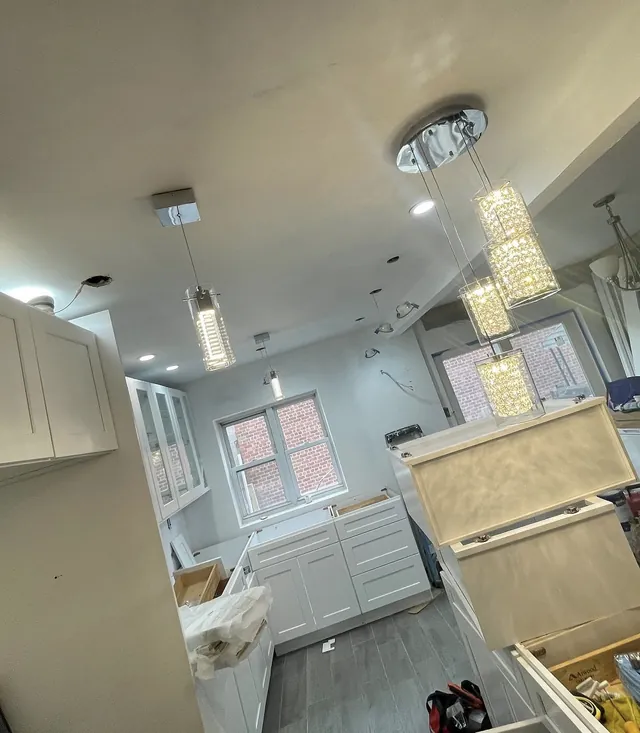 Finished kitchen with crystal pendant lights and recessed lighting