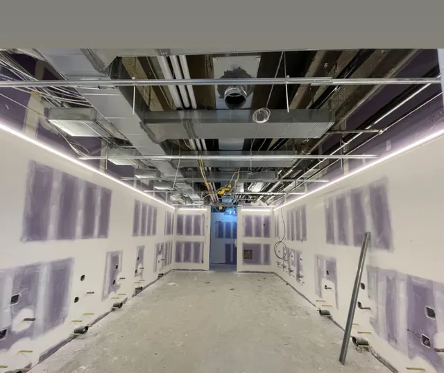 Commercial space under construction with linear LED lights along an open ceiling