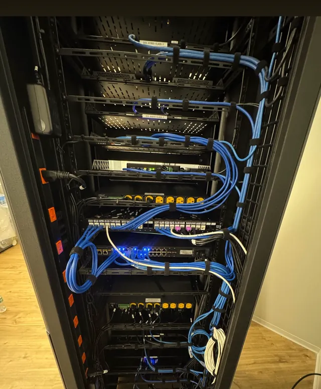 Floor-standing network rack with neatly routed blue patch cables