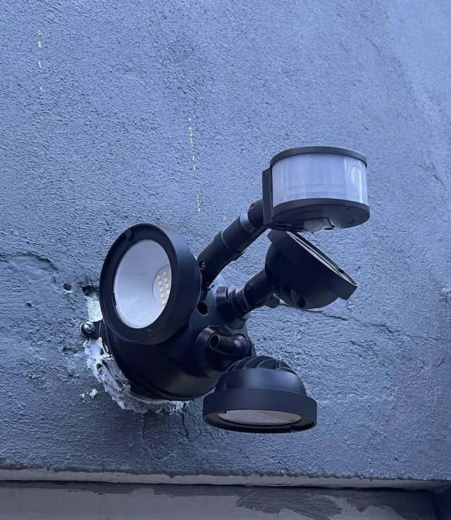 New dual-head LED motion sensor flood light installed on exterior wall