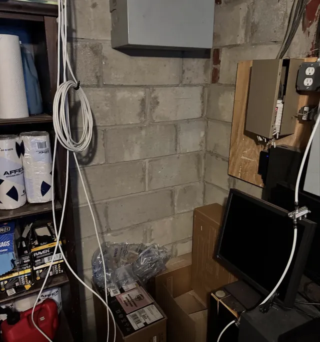 Loose security cabling and equipment on a basement wall before upgrade