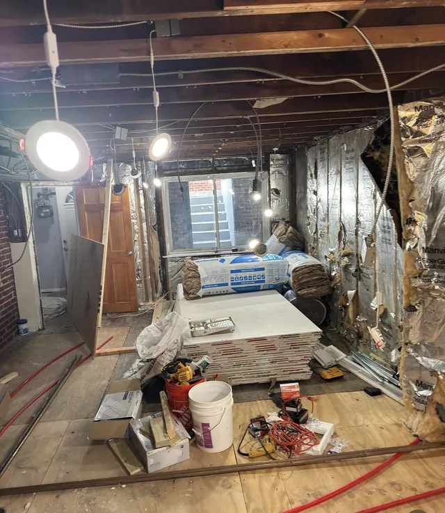 Gutted renovation space with open ceiling joists and new electrical runs